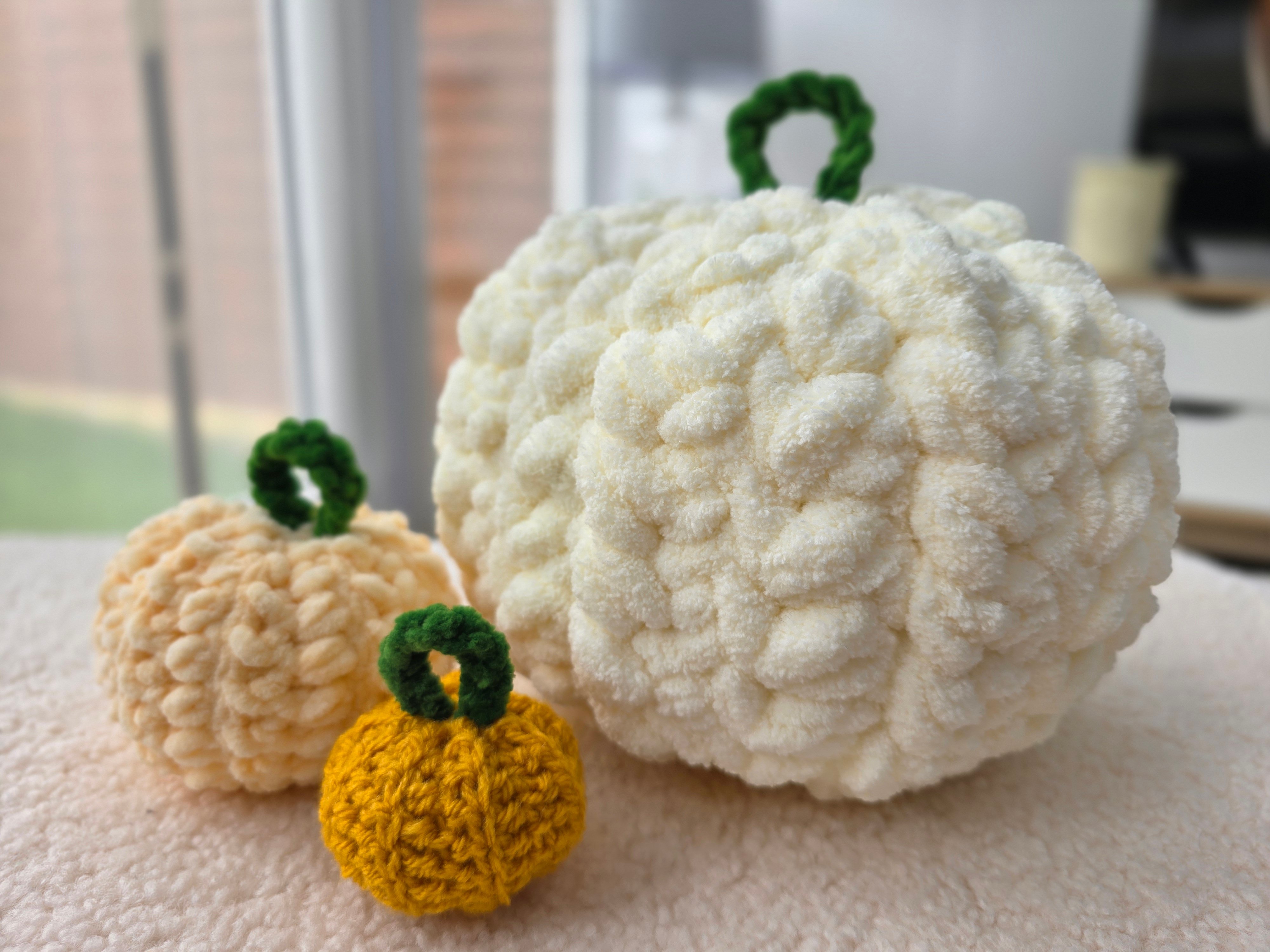 Free Crochet Pumpkins Pattern Three different sized crochet pumpkins sat together.