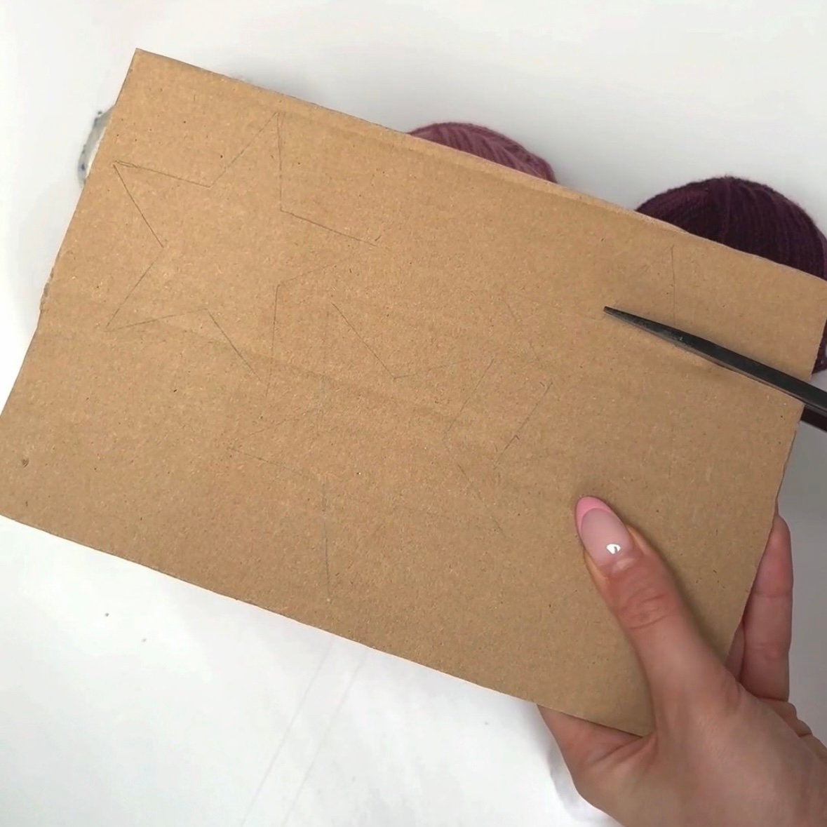 DIY Yarn-wrapped Star Ornaments Step 1 Create your base star using cardboard.