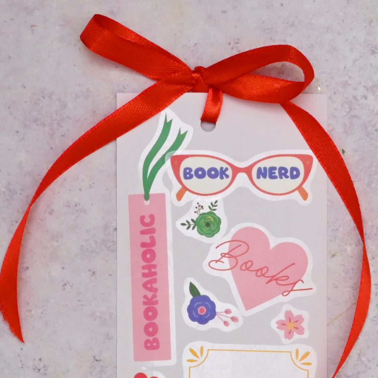 Red ribbon tied in a bow through the hole in the card.