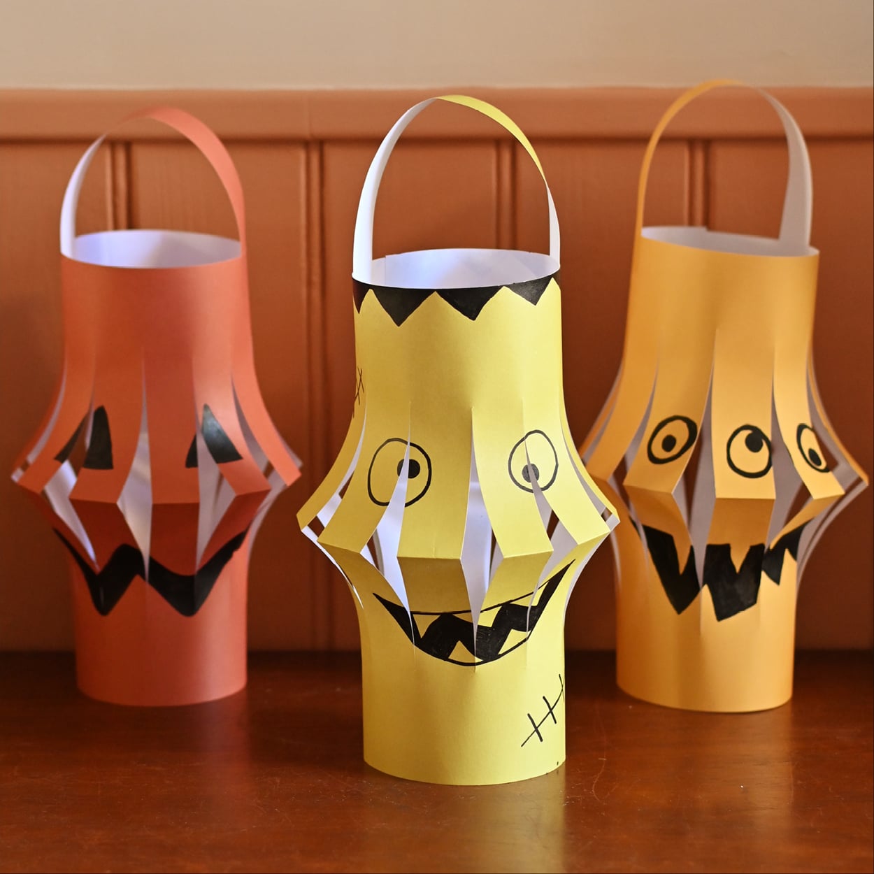 DIY Halloween paper lantern craft with spooky monster and pumpkin designs