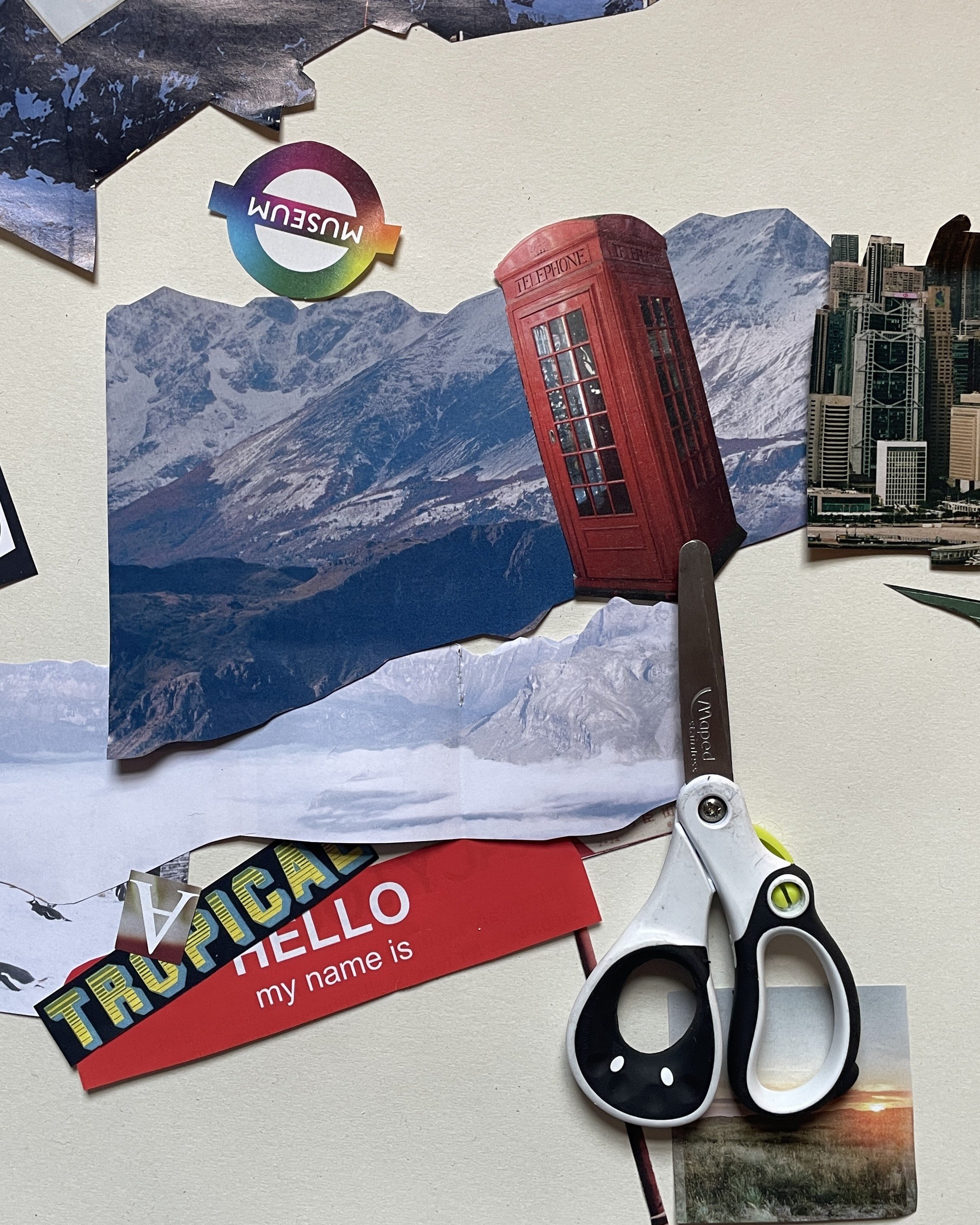 Cut outs of images, including a red phone box, mountains, skyscrapers, and a pair of scissors.