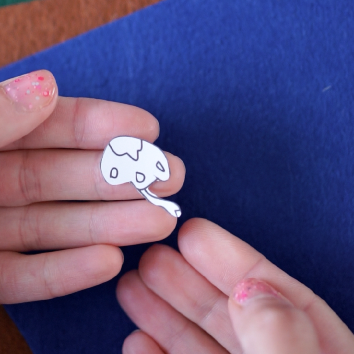 Step 2: Start with the Largest Shape Scissors cutting out felt around the shape form the colouring page.#