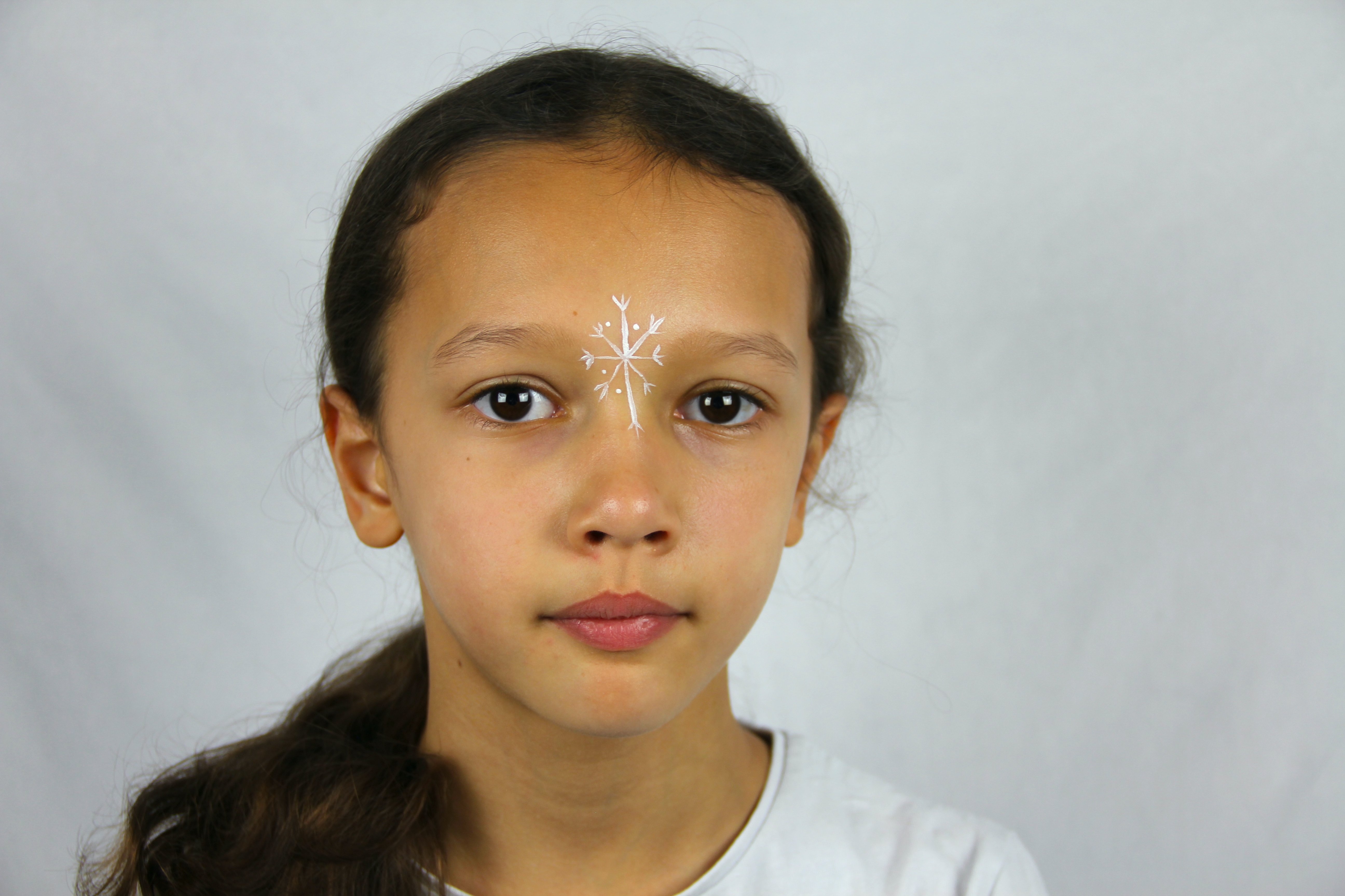 Using a brush and some white paint, add a snowflake in between the eyes.